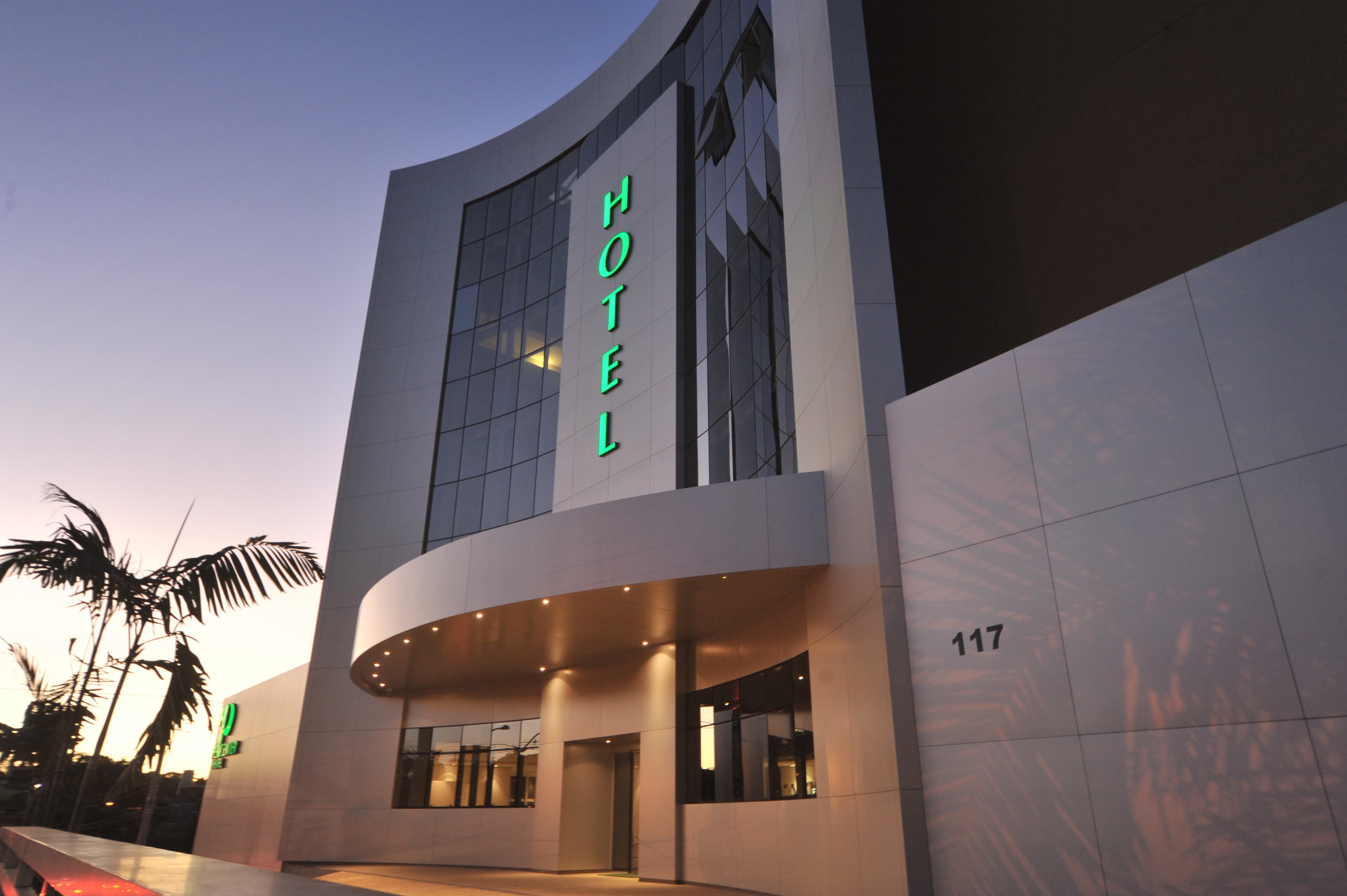 Detalhe de fachada em ACM com reflexo metálico ao entardecer